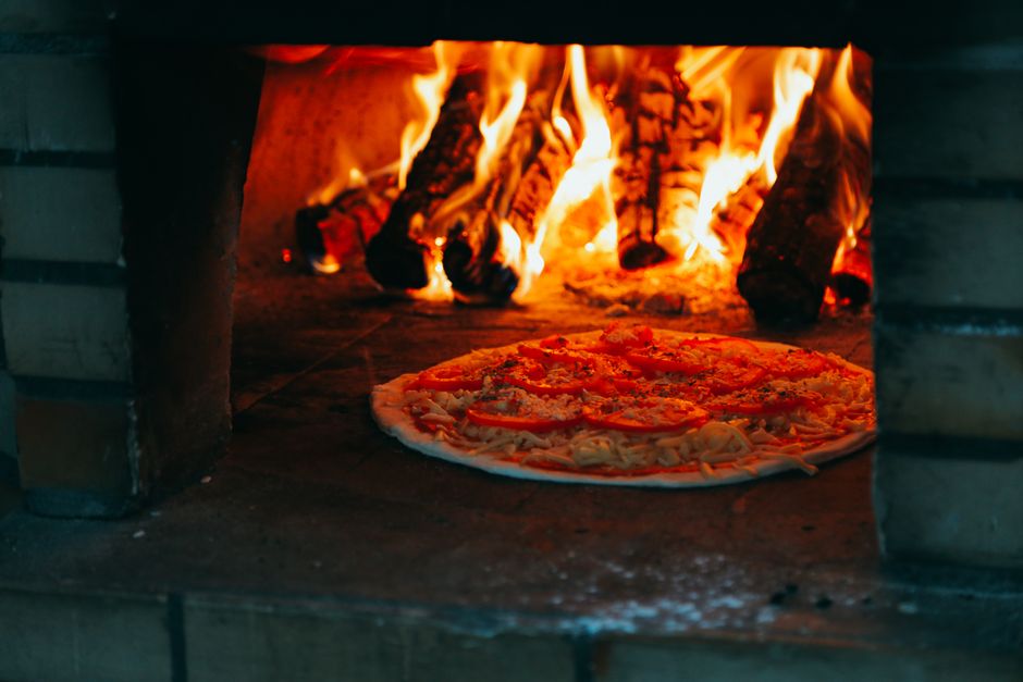 Traditional brick and stone pizza oven construction with outdoor setting